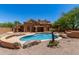 Desert home showcasing a pool with rock features and covered patio at 11238 N 11Th St, Phoenix, AZ 85020
