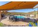 Shaded poolside patio with an outdoor dining set and lounge chairs, with a view of the community pool and surrounding landscape at 11238 N 11Th St, Phoenix, AZ 85020