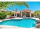 Amazing backyard featuring a sparkling pool with a waterfall, mature landscaping, and custom stonework at 12120 E Cortez Dr, Scottsdale, AZ 85259