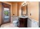 Bathroom with a dark wood vanity, patterned tile, and a door to the backyard at 12120 E Cortez Dr, Scottsdale, AZ 85259