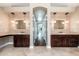 Bathroom vanity with double sinks, decorative mirrors, and tiled floors, leading to hall at 12120 E Cortez Dr, Scottsdale, AZ 85259