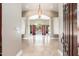 Spacious foyer featuring tiled floors, an elegant chandelier and large windows overlooking a backyard pool at 12120 E Cortez Dr, Scottsdale, AZ 85259