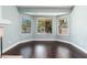 Cozy living room area offering views of the pool through bay windows and hardwood floors at 12120 E Cortez Dr, Scottsdale, AZ 85259