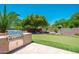Backyard putting green and outdoor kitchen with built in gas grill at 12120 E Cortez Dr, Scottsdale, AZ 85259
