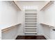 A bright walk-in closet with white shelving and hardwood floors at 12120 E Cortez Dr, Scottsdale, AZ 85259