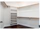 A bright walk-in closet with white shelving and hardwood floors at 12120 E Cortez Dr, Scottsdale, AZ 85259
