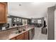 Modern kitchen with wood cabinets, stainless steel appliances, and breakfast bar area at 12228 N 122Nd Dr, El Mirage, AZ 85335