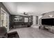 Spacious living room featuring gray walls, a ceiling fan, wood-look floors, and a sliding glass door to the backyard at 12228 N 122Nd Dr, El Mirage, AZ 85335