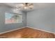 A bright bedroom featuring hardwood flooring, a ceiling fan, and a window offering natural light at 12459 N 36Th St, Phoenix, AZ 85032