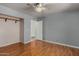 Bedroom features hardwood flooring, a ceiling fan, and a closet with an open door at 12459 N 36Th St, Phoenix, AZ 85032