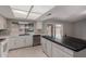 Bright kitchen features white cabinets, stainless steel appliances, and an island with a dark countertop at 12459 N 36Th St, Phoenix, AZ 85032