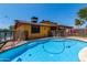 Backyard pool surrounded by artificial grass and a yellow house with a covered patio at 12459 N 36Th St, Phoenix, AZ 85032