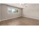 Bright bedroom featuring wood-look floors, ceiling fan, and large window offering plenty of natural light at 1502 E Minton Dr, Tempe, AZ 85282