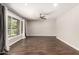 Spacious living room with wood-look flooring, neutral walls, ceiling fan, and a bright window at 1502 E Minton Dr, Tempe, AZ 85282