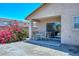 The cozy covered patio features a simple outdoor dining set, overlooking desert landscaping and a vibrant bougainvillea bush at 1527 S 219Th Ln, Buckeye, AZ 85326