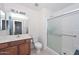 Bright bathroom featuring a wood vanity and a shower with sliding doors at 1527 S 219Th Ln, Buckeye, AZ 85326