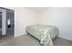 Neutral bedroom featuring a bed with a green patterned quilt and an open doorway at 1527 S 219Th Ln, Buckeye, AZ 85326