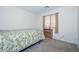 Neutral bedroom featuring a bed with a green patterned quilt and a window at 1527 S 219Th Ln, Buckeye, AZ 85326