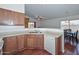 Open-concept kitchen with stainless steel sink, white dishwasher, and wooden cabinetry at 1527 S 219Th Ln, Buckeye, AZ 85326