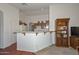 Functional kitchen with a breakfast bar, white appliances, and ample cabinet space for storage at 1527 S 219Th Ln, Buckeye, AZ 85326