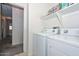 Bright laundry room offers in-unit white washer and dryer plus ample shelving space for storage at 1527 S 219Th Ln, Buckeye, AZ 85326