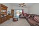 Cozy living room with hardwood bookcase, a ceiling fan, and a large comfortable sofa at 1527 S 219Th Ln, Buckeye, AZ 85326