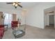 Open living space with neutral carpeting, a glass coffee table, and bright windows at 1527 S 219Th Ln, Buckeye, AZ 85326