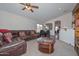 Spacious living room featuring a leather sofa, and open floor plan with access to the dining area at 1527 S 219Th Ln, Buckeye, AZ 85326