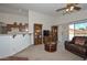 Comfortable living area with sliding glass doors, open kitchen access, and wooden bookshelves at 1527 S 219Th Ln, Buckeye, AZ 85326