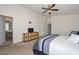 Spacious main bedroom featuring a ceiling fan, doorways, and a tv sitting on a decorative dresser at 1527 S 219Th Ln, Buckeye, AZ 85326