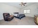 Spacious main bedroom featuring a ceiling fan and a leather chair in the corner at 1527 S 219Th Ln, Buckeye, AZ 85326