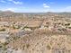 Expansive aerial of desert community featuring neutral homes surrounded by natural landscape and rolling hills at 1550 W Adobe Dam Dr, San Tan Valley, AZ 85144