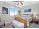 Bright bedroom with wooden bed frame, white cushioned bench, and scenic mountain artwork at 1550 W Adobe Dam Dr, San Tan Valley, AZ 85144