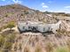 A Southwestern-style home on a desert hillside with flat roof, neutral color scheme, and mountain views at 1550 W Adobe Dam Dr, San Tan Valley, AZ 85144