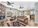 Warm living room with stone fireplace, patterned rug, and mountain views, seamlessly connecting to the kitchen at 1550 W Adobe Dam Dr, San Tan Valley, AZ 85144