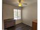 Cozy bedroom with a ceiling fan, window with blinds, and decorative dresser at 1643 E Oakland St, Chandler, AZ 85225