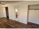 Bright bedroom featuring wood floors, closet, and a mirrored door leading to another room at 1643 E Oakland St, Chandler, AZ 85225