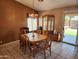 Dining room boasts a wooden table with seating for six, accentuated by a classic chandelier and lots of natural light at 1643 E Oakland St, Chandler, AZ 85225