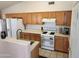 Functional kitchen featuring wooden cabinetry, white appliances, and a practical layout for easy meal preparation at 1643 E Oakland St, Chandler, AZ 85225