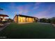 Expansive backyard featuring artificial turf, a covered patio, and an outdoor kitchen area, ideal for relaxation and entertainment at 18835 W San Miguel Ave, Litchfield Park, AZ 85340