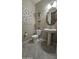Charming powder room featuring tile floors, a pedestal sink, and decorative wall art at 18835 W San Miguel Ave, Litchfield Park, AZ 85340