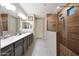 Modern bathroom with a double vanity, tiled shower, and glass partition at 18835 W San Miguel Ave, Litchfield Park, AZ 85340