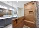 Modern bathroom featuring dual sinks and a tiled shower with a built-in bench at 18835 W San Miguel Ave, Litchfield Park, AZ 85340