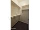 Compact closet featuring multiple storage shelves and hanging rods for organization at 18835 W San Miguel Ave, Litchfield Park, AZ 85340