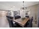 Open concept dining area featuring a wooden table, upholstered chairs, stylish light fixture, and kitchen views at 18835 W San Miguel Ave, Litchfield Park, AZ 85340