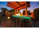 Outdoor fire bar featuring a built-in grill, pendant lighting, bar seating, and decorative landscaping at 18835 W San Miguel Ave, Litchfield Park, AZ 85340