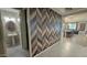 Hallway featuring stylish wood patterned wall that leads to a powder room and dining area for seamless living at 18835 W San Miguel Ave, Litchfield Park, AZ 85340