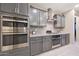 Modern kitchen featuring stainless steel appliances, granite countertops, subway tile backsplash, and gray cabinets at 18835 W San Miguel Ave, Litchfield Park, AZ 85340