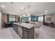 Open-concept kitchen island with stainless steel dishwasher and sink, views of dining and living areas at 18835 W San Miguel Ave, Litchfield Park, AZ 85340
