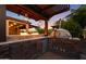 Stunning outdoor kitchen with pizza oven, built-in grill, and fire feature, perfect for entertaining guests at 18835 W San Miguel Ave, Litchfield Park, AZ 85340